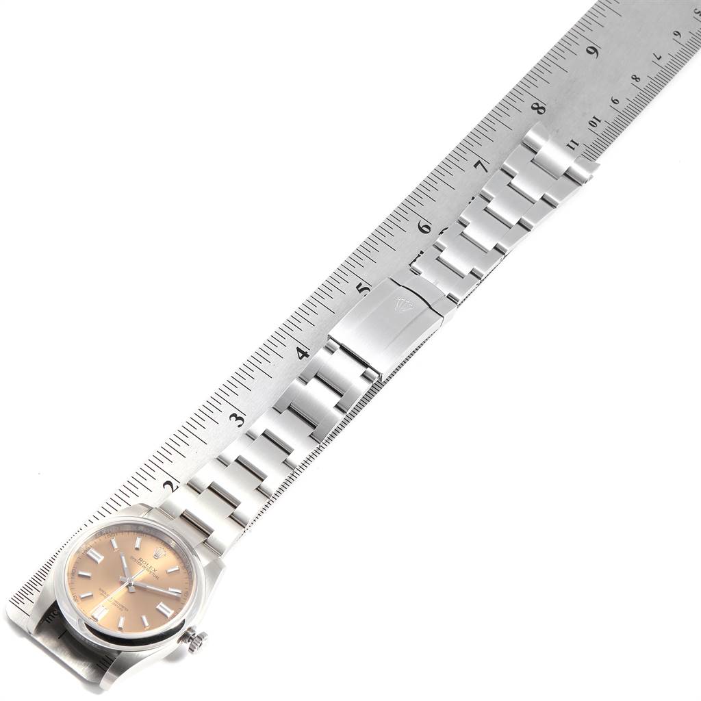 The image shows the Rolex Oyster Perpetual 116000 Men's Stainless Steel Champagne Dial 116000 Men's Stainless Steel Champagne Dial watch laid flat with a metal bracelet next to a ruler, demonstrating its length.