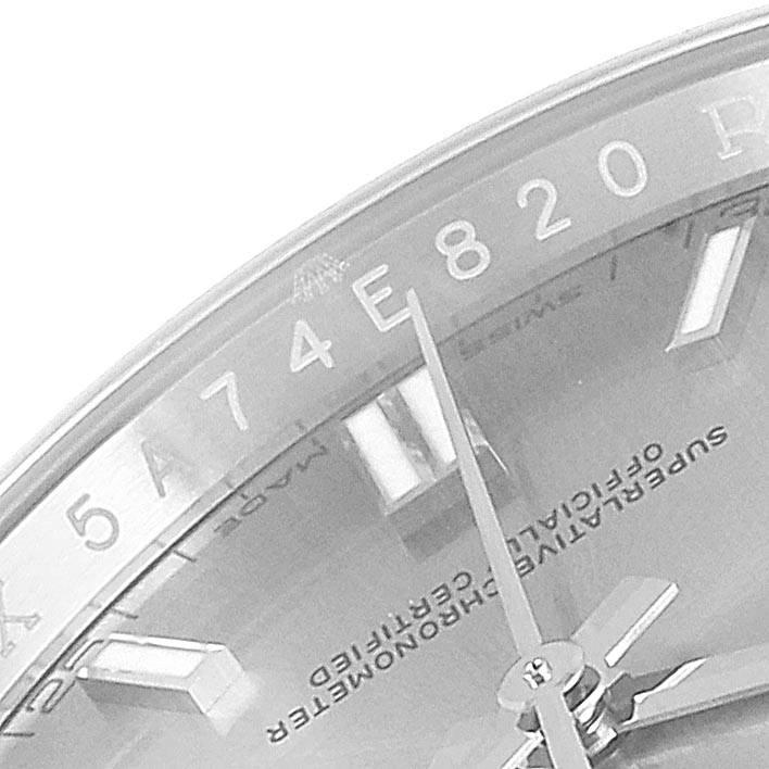 This close-up image of a Rolex Oyster Perpetual 116000 Men's Stainless Steel Grey Dial 116000 Men's Stainless Steel Grey Dial shows the dial, hands, and part of the internal markings.
