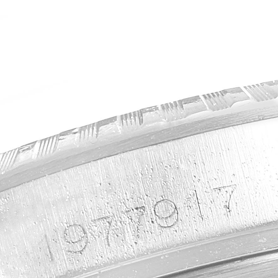 The image shows a close-up of the engraved serial number and the edge of the bezel of a Rolex Oyster Perpetual 1603 Men
s Stainless Steel Silver Dial 1603 Men
s Stainless Steel Silver Dial watch.