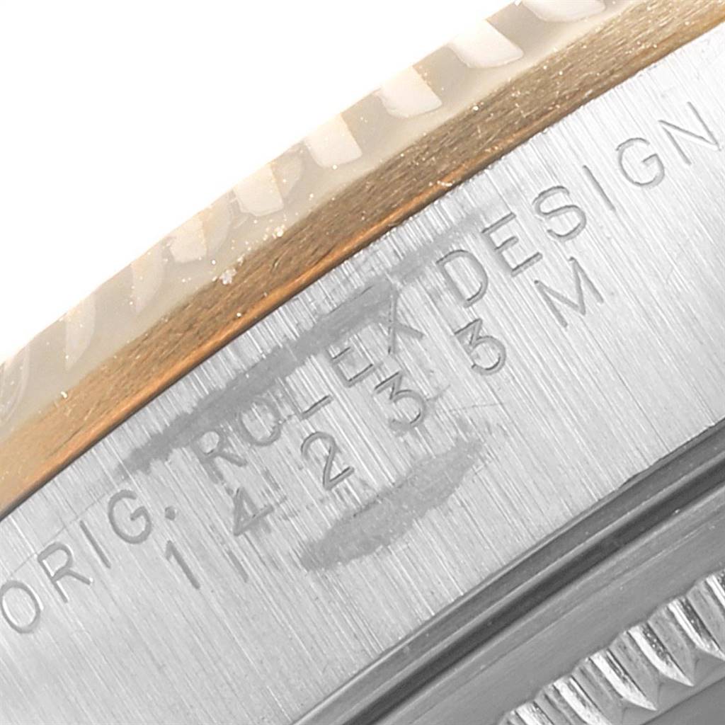 This close-up image shows the case side of a Rolex Oyster Perpetual 14233 Men's Steel and Gold (two tone) Blue Dial 14233 Men's Steel and Gold (two tone) Blue Dial watch with engraved serial and model numbers.