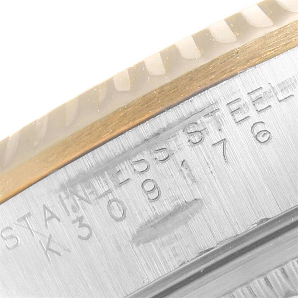 This close-up image shows the serial number and the fluted edge of the bezel of a Rolex Oyster Perpetual 14233 Men's Steel and Gold (two tone) Blue Dial 14233 Men's Steel and Gold (two tone) Blue Dial watch.