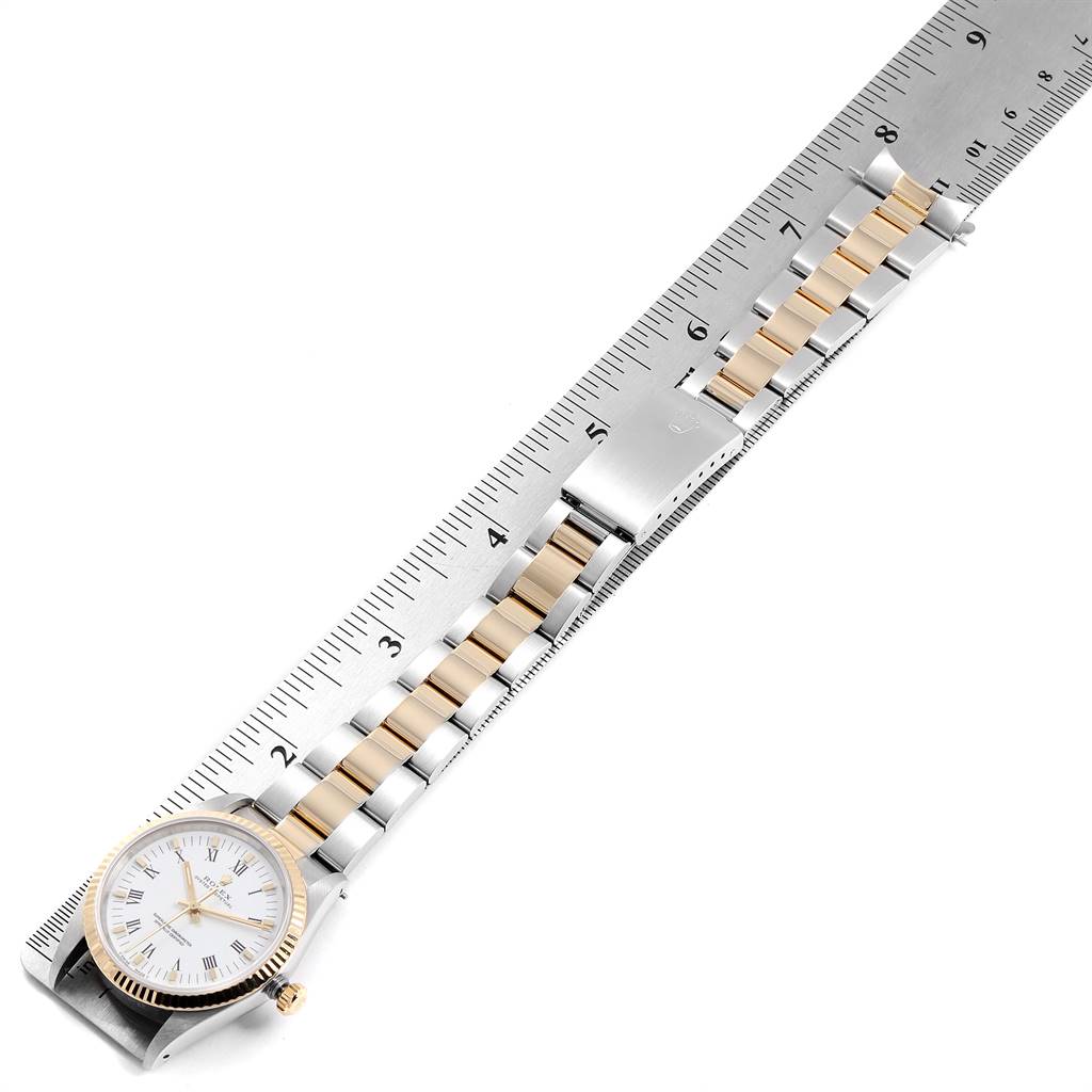 The image displays a Rolex Oyster Perpetual 14233 Men
s Steel and Gold (two tone) White Dial 14233 Men
s Steel and Gold (two tone) White Dial watch placed alongside a ruler, showing the full bracelet, watch face, and clasp.