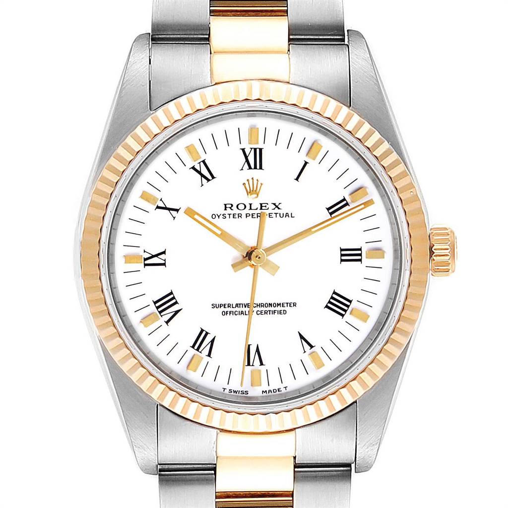 The Rolex Oyster Perpetual 14233 Men
s Steel and Gold (two tone) White Dial 14233 Men
s Steel and Gold (two tone) White Dial watch is shown from a front angle, displaying its face, bezel, and a partial view of its bracelet.