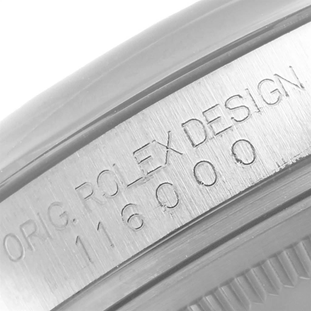 This is a close-up view of the engraved side of the casing of a Rolex Oyster Perpetual 116000 Men's Stainless Steel Grey Dial 116000 Men's Stainless Steel Grey Dial model watch.