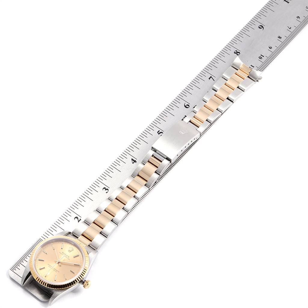 The image shows a top-down view of a Rolex Oyster Perpetual 14233 Men
s Steel and Gold (two tone) Champagne Dial 14233 Men
s Steel and Gold (two tone) Champagne Dial watch with its band laid along a ruler.