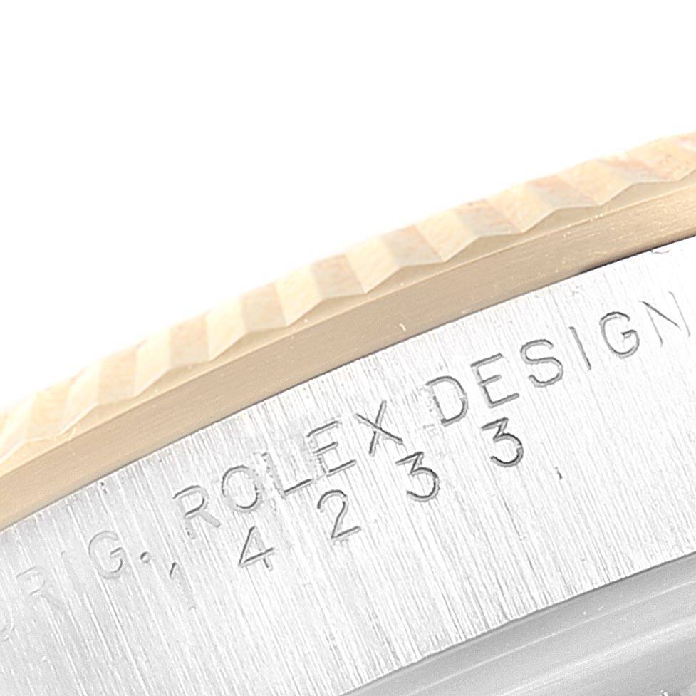 This image shows a close-up of the side of the bezel and case, featuring engraved text on a Rolex Oyster Perpetual 14233 Men
s Steel and Gold (two tone) Champagne Dial 14233 Men
s Steel and Gold (two tone) Champagne Dial watch.