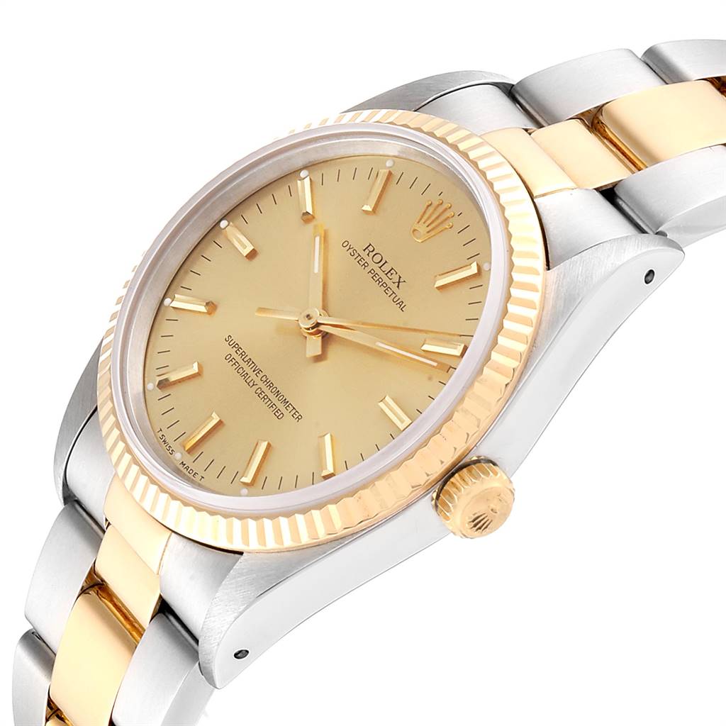 The Rolex Oyster Perpetual 14233 Men
s Steel and Gold (two tone) Champagne Dial 14233 Men
s Steel and Gold (two tone) Champagne Dial watch is shown at an oblique angle, highlighting its gold-toned bezel, dial, and part of its bracelet.