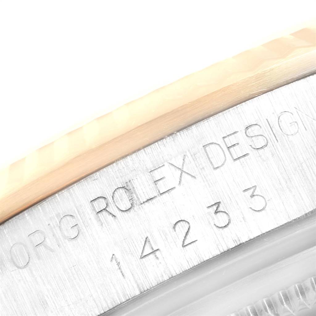 This close-up image shows the side of the bezel and case with engraved text and serial number of a Rolex Oyster Perpetual 14233 Men
s Steel and Gold (two tone) Champagne Dial 14233 Men
s Steel and Gold (two tone) Champagne Dial watch.