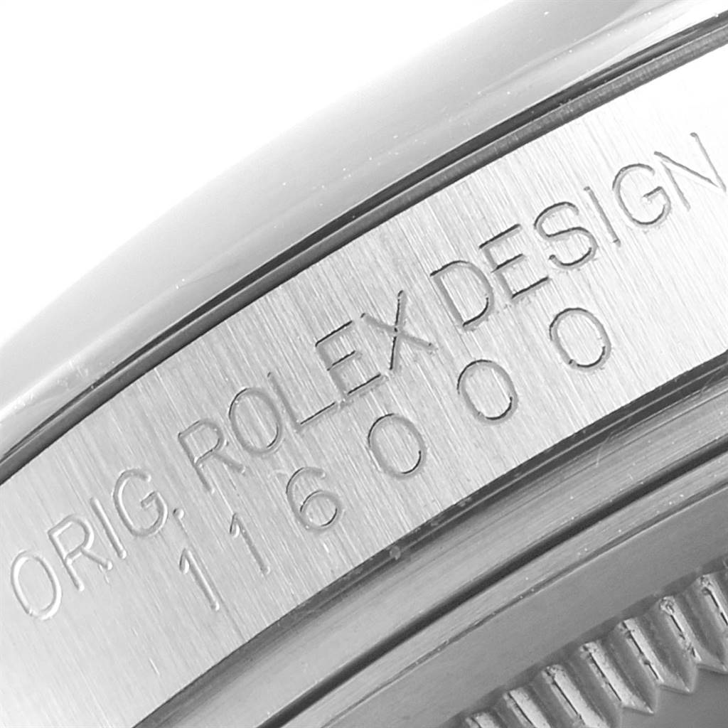 This close-up image shows the side of a Rolex Oyster Perpetual 116000 Men
s Stainless Steel Champagne Dial 116000 Men
s Stainless Steel Champagne Dial watch with the model number 116000 engraved on it.