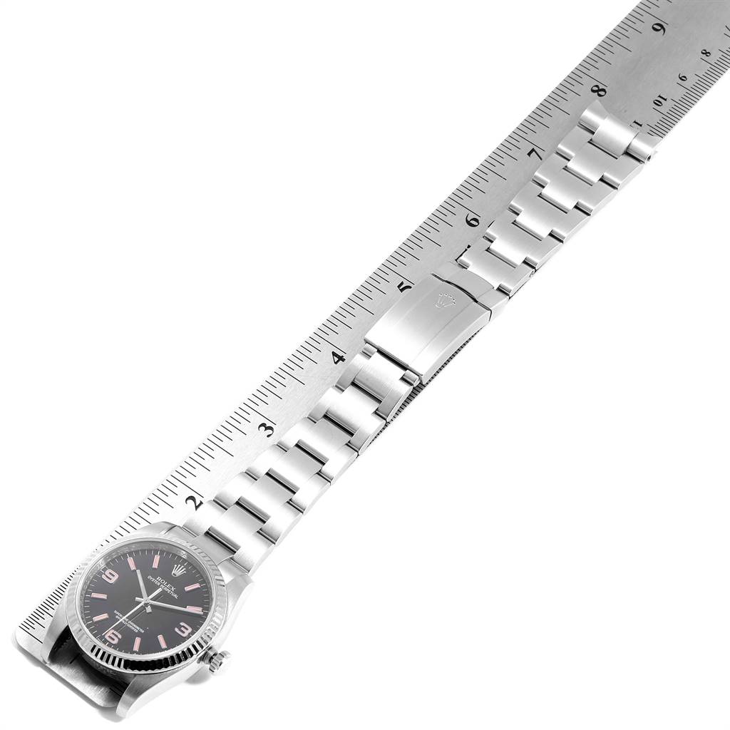 The image shows the Rolex Oyster Perpetual 116034 Men's Stainless Steel Black Dial 116034 Men's Stainless Steel Black Dial watch fully extended alongside a ruler, displaying its face and bracelet.