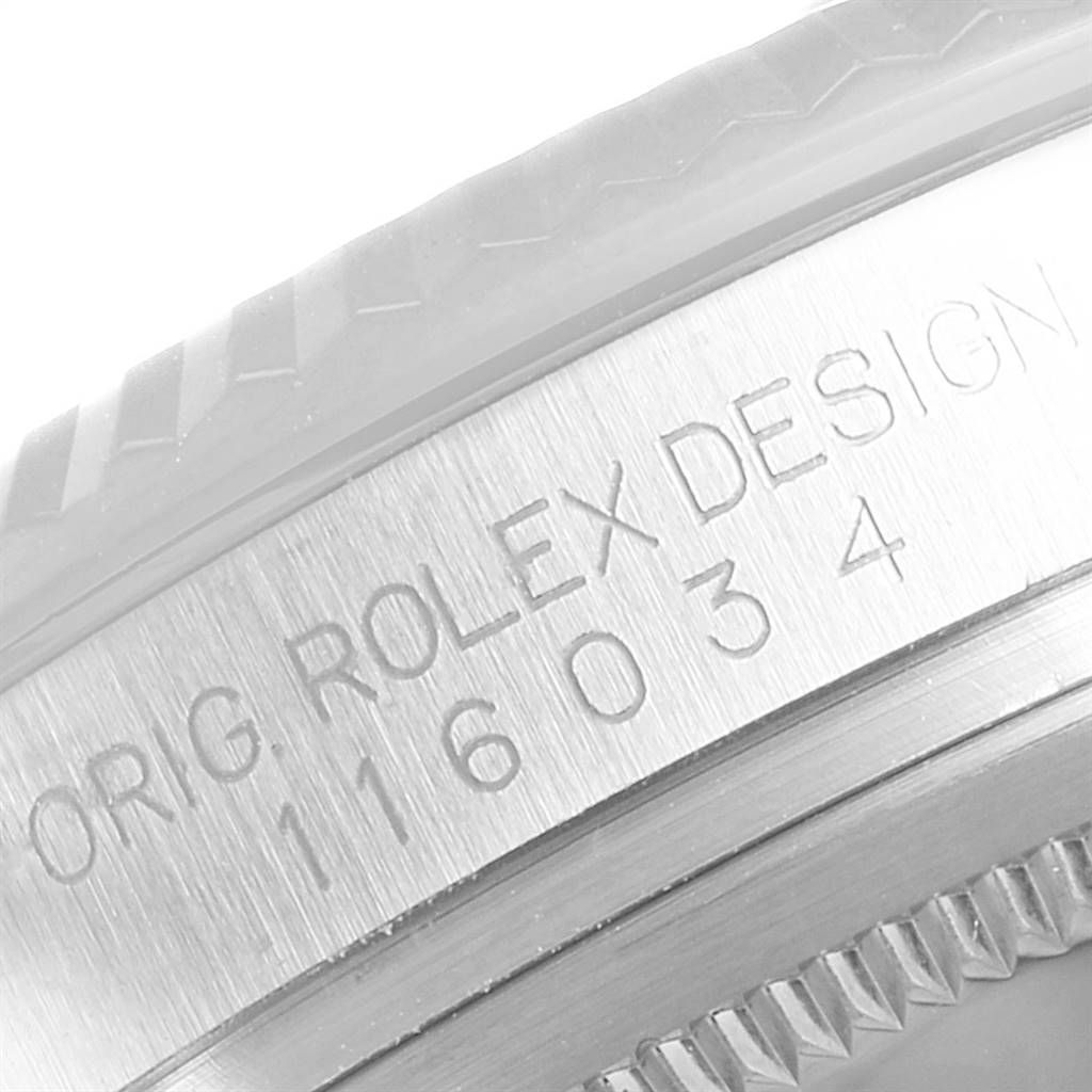 This close-up image shows the engraved bezel and part of the case of a Rolex Oyster Perpetual 116034 Men's Stainless Steel Black Dial 116034 Men's Stainless Steel Black Dial watch.