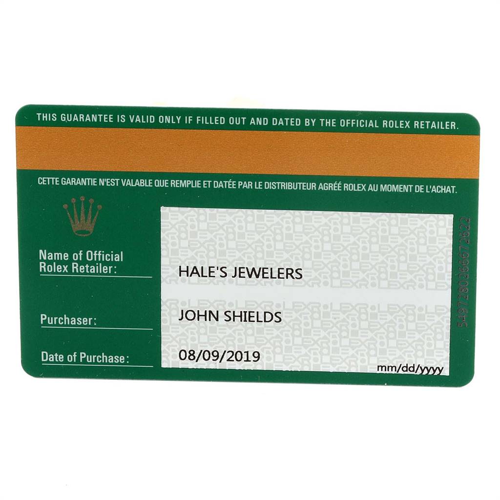 This image shows a warranty card for the Rolex Oyster Perpetual 114200 Men's Stainless Steel Blue Dial 114200 Men's Stainless Steel Blue Dial model from an overhead angle.