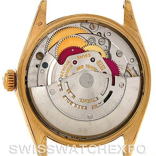 The image shows the back view of a Rolex Oyster Perpetual Men
s Yellow Gold White Dial Men
s Yellow Gold White Dial watch, revealing its internal mechanical movement components.