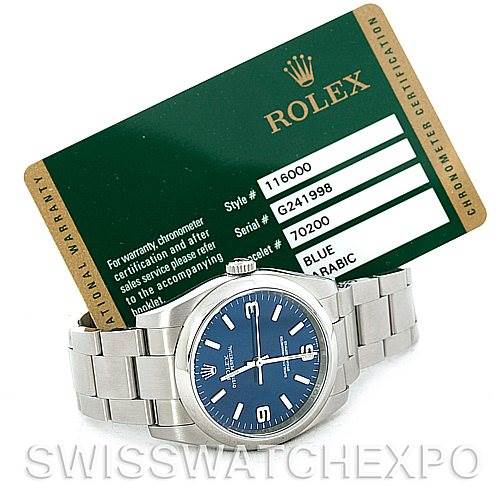 This image shows a Rolex Oyster Perpetual 116000BLASO Men's Stainless Steel Blue Dial 116000BLASO Men's Stainless Steel Blue Dial watch with a blue dial, alongside its warranty card.