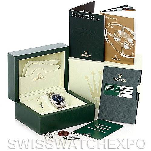 The image shows a Rolex Oyster Perpetual 116000BLASO Men's Stainless Steel Blue Dial 116000BLASO Men's Stainless Steel Blue Dial watch, its open green box, warranty card, manuals, and accessories at a slight angle.