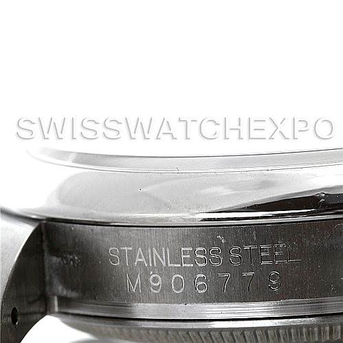 The image shows a close-up of the side of the Rolex Oyster Perpetual 116000 Men's Stainless Steel Black Dial 116000 Men's Stainless Steel Black Dial watch, specifically focusing on the engraved stainless steel case back and serial number.