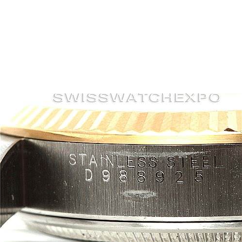 This close-up photo shows the side of a Rolex Oyster Perpetual 14233 Men's Steel and Gold (two tone) Silver Dial 14233 Men's Steel and Gold (two tone) Silver Dial watch, highlighting its stainless steel case and serial number.