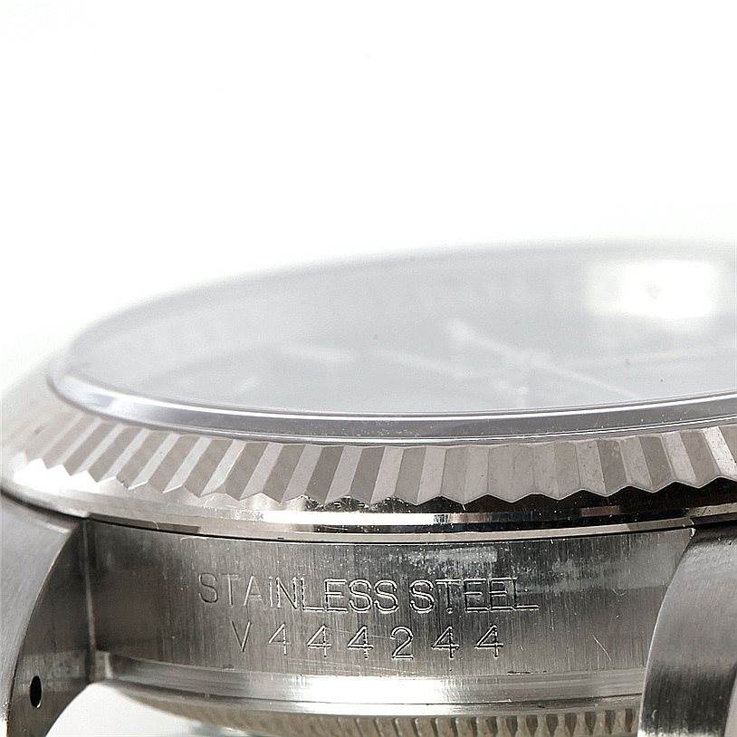 This image shows a close-up of the side view of a Rolex Oyster Perpetual 116034 Men's Stainless Steel Blue Dial 116034 Men's Stainless Steel Blue Dial watch, highlighting the case and bezel.