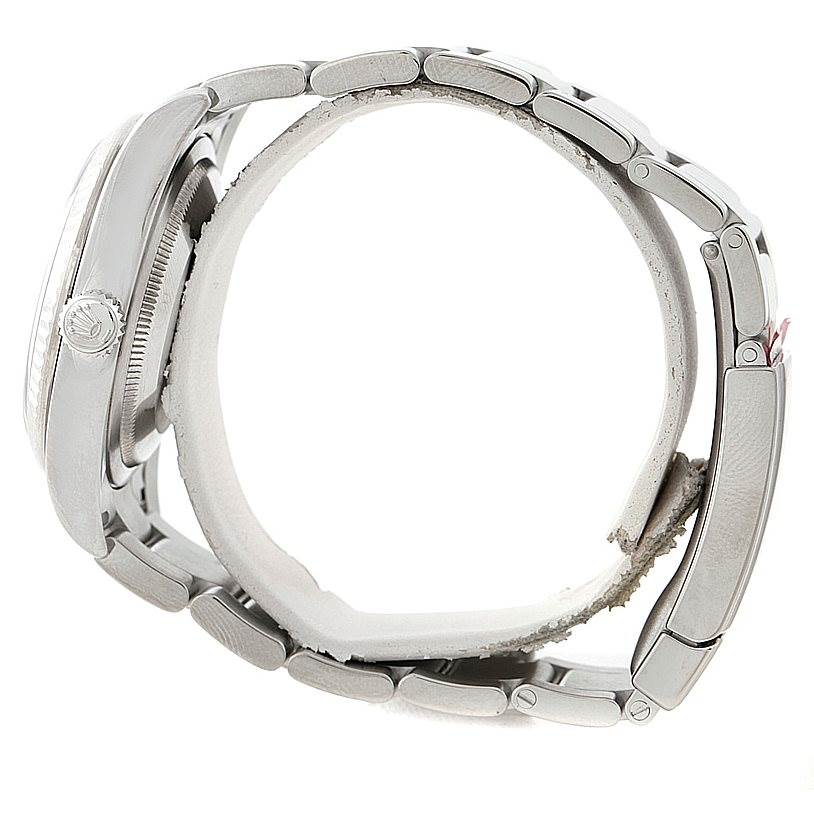 The image shows a side view of a Rolex Oyster Perpetual 116034 Men's Stainless Steel Blue Dial 116034 Men's Stainless Steel Blue Dial watch, highlighting the crown and metal bracelet.