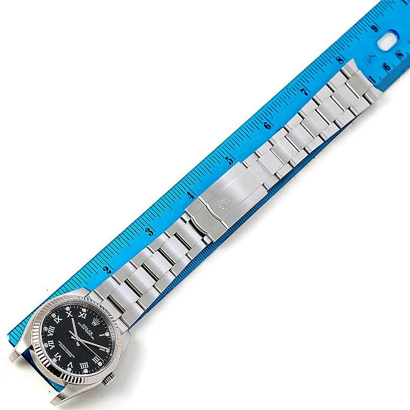 The image shows a Rolex Oyster Perpetual 116034 Men
s Stainless Steel Black Dial 116034 Men
s Stainless Steel Black Dial watch laid alongside a ruler, highlighting the face and full bracelet.