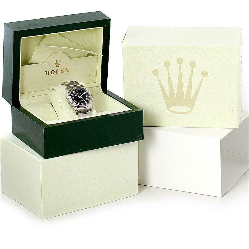 This image shows a Rolex Oyster Perpetual 116034 Men
s Stainless Steel Black Dial 116034 Men
s Stainless Steel Black Dial watch in its open green and beige presentation box, with a larger outer box beside it.
