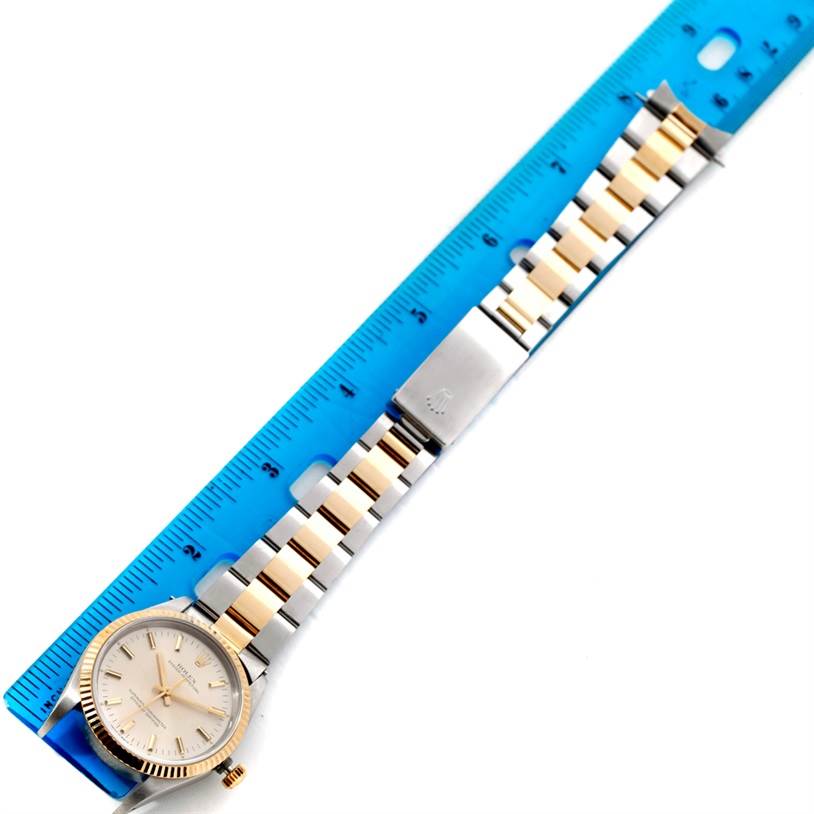 The image shows a top view of a Rolex Oyster Perpetual 14233 Men's Steel and Gold (two tone) Silver Dial 14233 Men's Steel and Gold (two tone) Silver Dial watch with its two-tone bracelet placed next to a ruler.