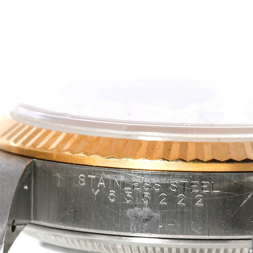 The image shows a close-up, side view angle of the bezel and part of the case of the Rolex Oyster Perpetual 14233 Men's Steel and Gold (two tone) Champagne Dial 14233 Men's Steel and Gold (two tone) Champagne Dial watch, highlighting the serial number.