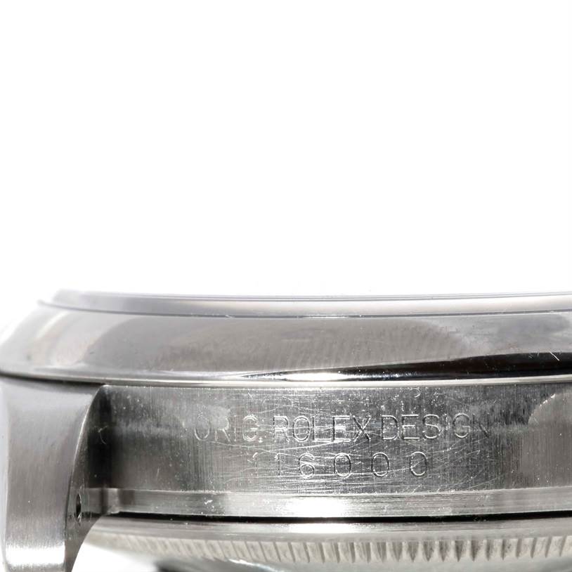 The image shows a close-up side view of the case and bezel of a Rolex Oyster Perpetual M831438 Men's Stainless Steel Black Dial M831438 Men's Stainless Steel Black Dial watch, featuring engraved text.