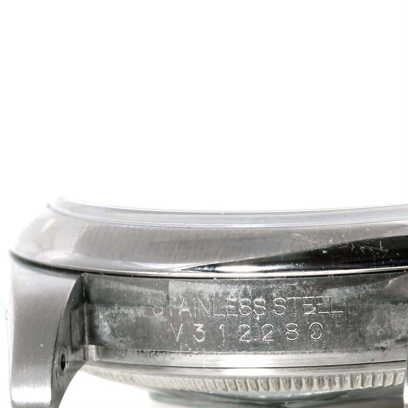 The image shows a close-up side view of the stainless steel case back and bezel of a Rolex Oyster Perpetual 116000 Men's Stainless Steel Silver Dial 116000 Men's Stainless Steel Silver Dial watch.