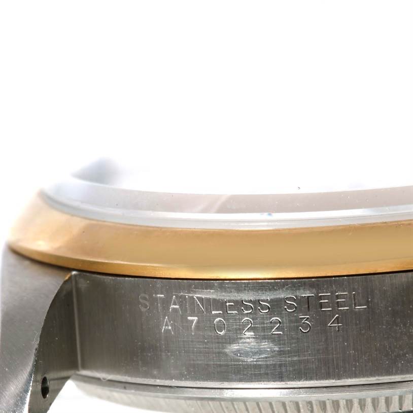 The image shows a side view angle of the Rolex Oyster Perpetual 14203 Men
s Steel and Gold (two tone) Grey Dial 14203 Men
s Steel and Gold (two tone) Grey Dial watch, focusing on the stainless steel casing and engraving.