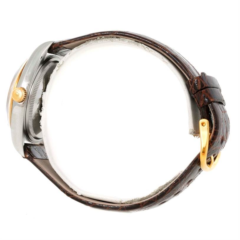 The image shows a side view of a Rolex Oyster Perpetual 14203 Men
s Steel and Gold (two tone) Grey Dial 14203 Men
s Steel and Gold (two tone) Grey Dial watch, highlighting its crown, case, and leather strap.