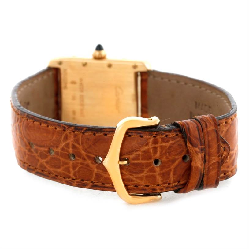 The image shows the back of the Tank Louis watch by Cartier, highlighting the leather strap, buckle, and case back.