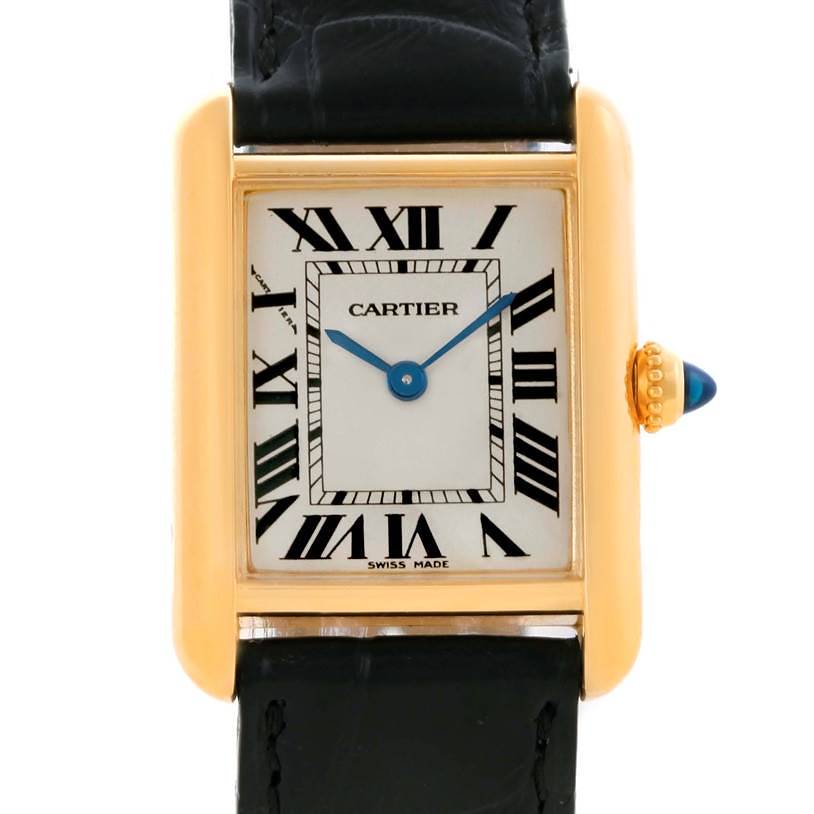 The image shows the face and right side of a Cartier Tank Louis watch, highlighting its Roman numerals and gold casing.