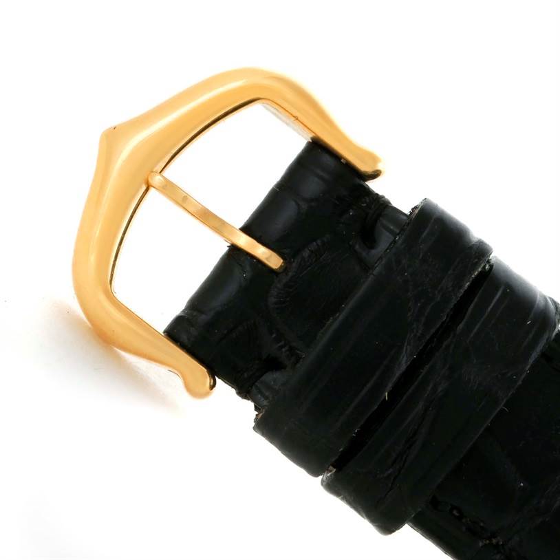 This image shows a close-up of the black leather strap and gold buckle of a Tank Louis model by Cartier.