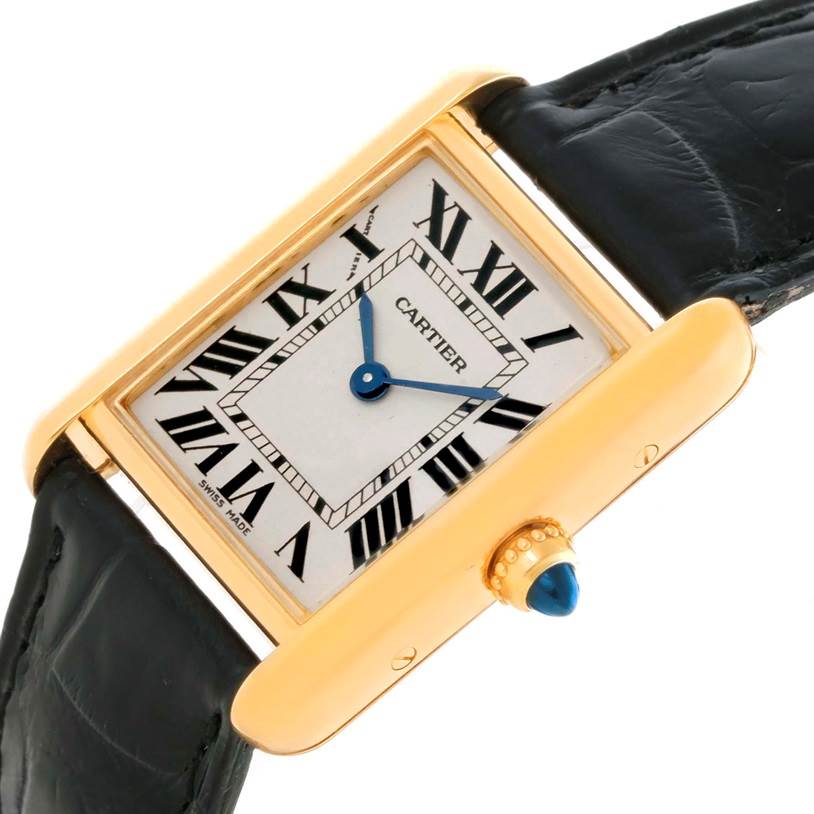 The image shows a close-up of the face, crown, and part of the strap of the Tank Louis watch by Cartier.