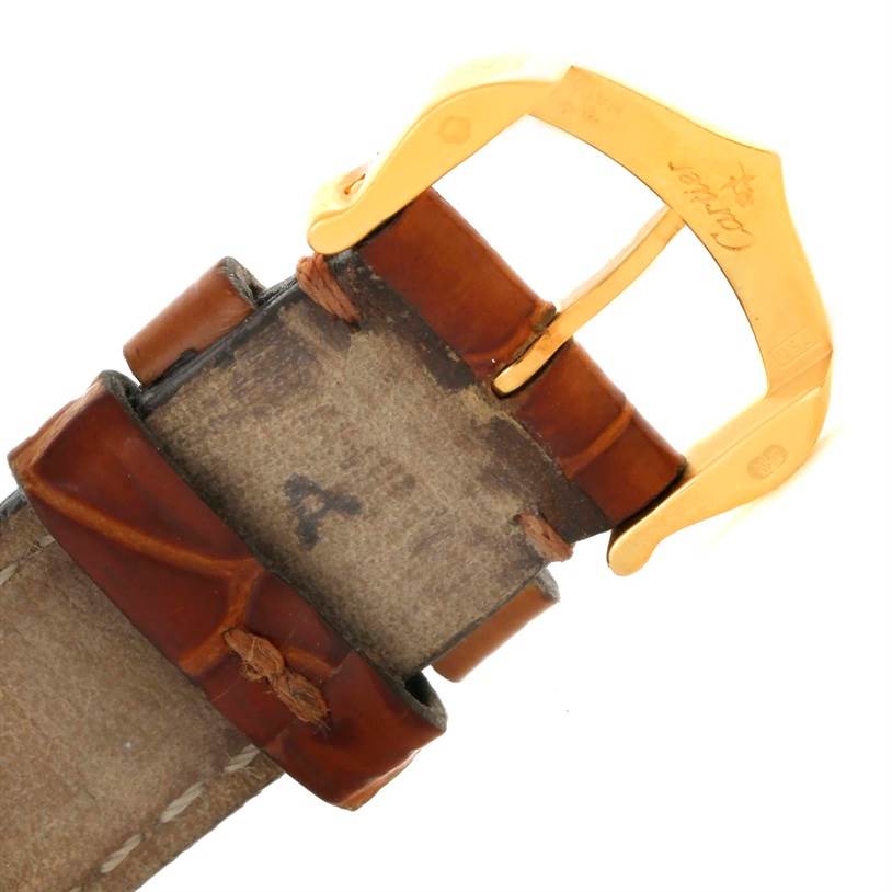 This is an angled view of the leather strap and gold buckle of a Tank Louis model by Cartier.
