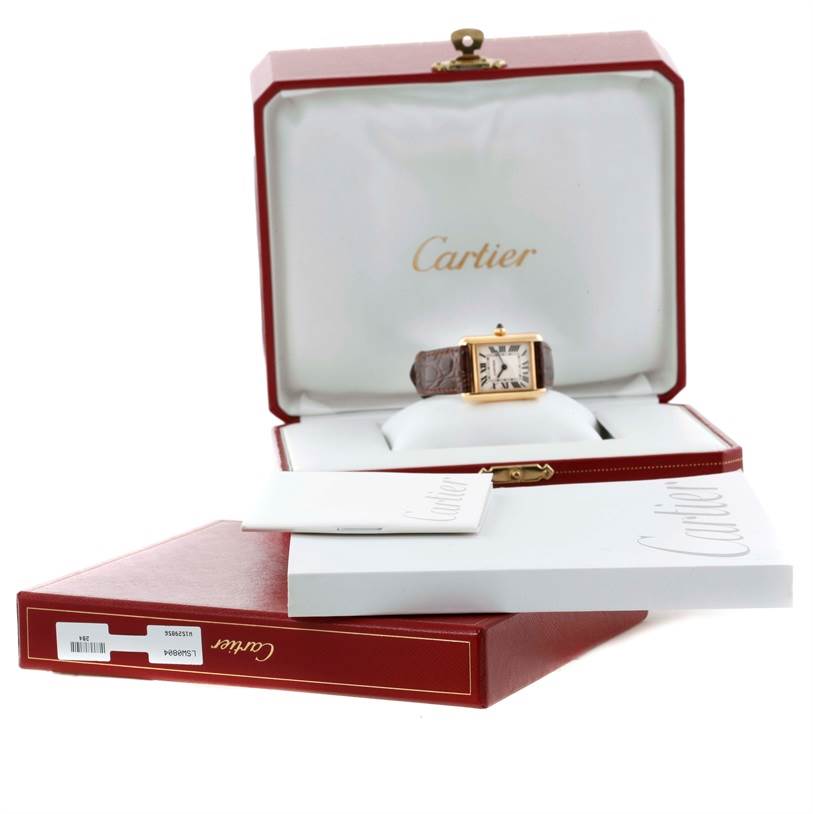 The image shows a Cartier Tank Louis W1529856 Women's Yellow Gold Silver Dial W1529856 Women's Yellow Gold Silver Dial watch in its open box with additional packaging and booklets displayed.