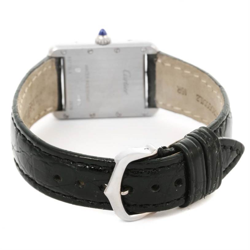 The image shows the Tank Louis model by Cartier from the rear, focusing on the clasp, leather strap, and case back.