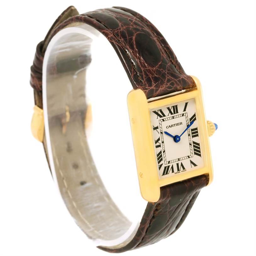The image shows a Tank Louis Cartier watch angled slightly to display its face, gold case, and leather strap.