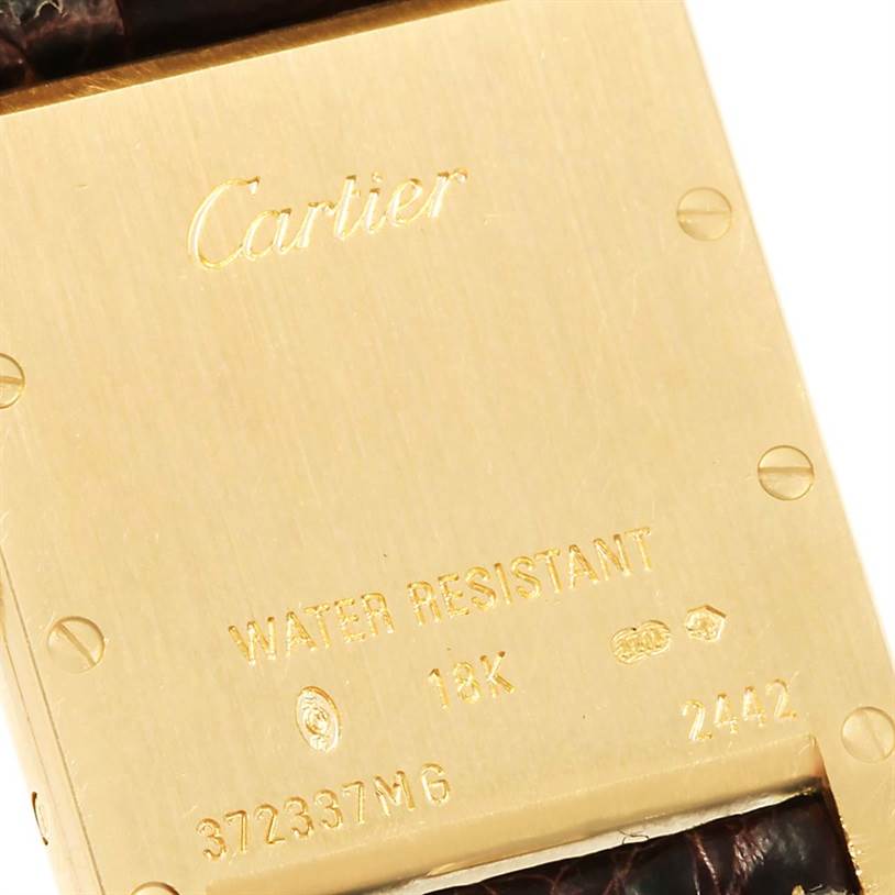 The image shows the back of a Tank Louis model by Cartier, including its metal case, engravings, and part of the leather strap.