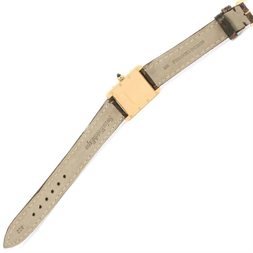 The image shows the backside of a Tank Louis watch by Cartier, highlighting the case back and leather strap with stitching.