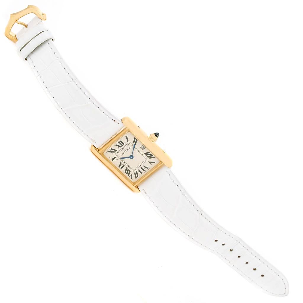 The image shows a Cartier Tank Louis W1529756 Women's Yellow Gold Silver Dial W1529756 Women's Yellow Gold Silver Dial watch, with a white leather strap, gold case, and visible Roman numeral dial, in a top-down angle.