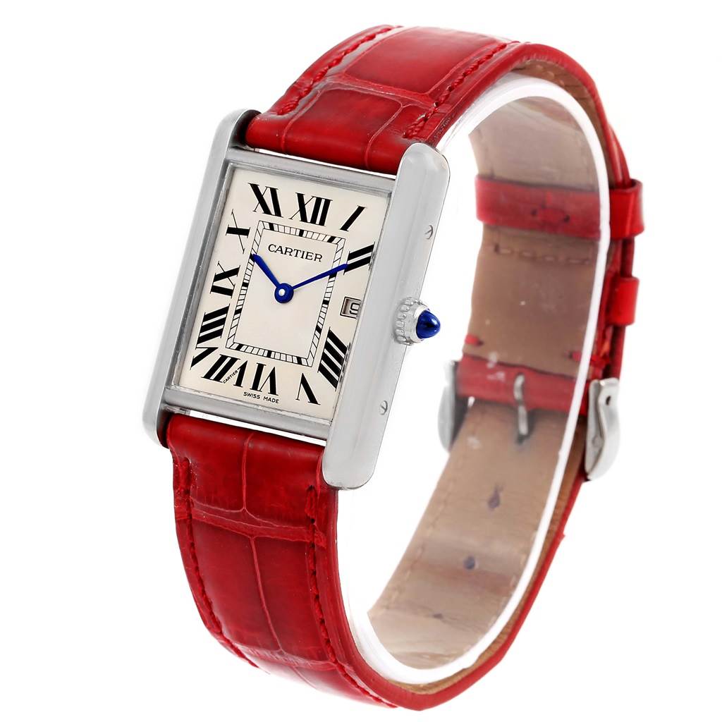 The Tank Louis model by Cartier is shown at an angled view, highlighting the dial, red leather strap, and crown with a blue gem.