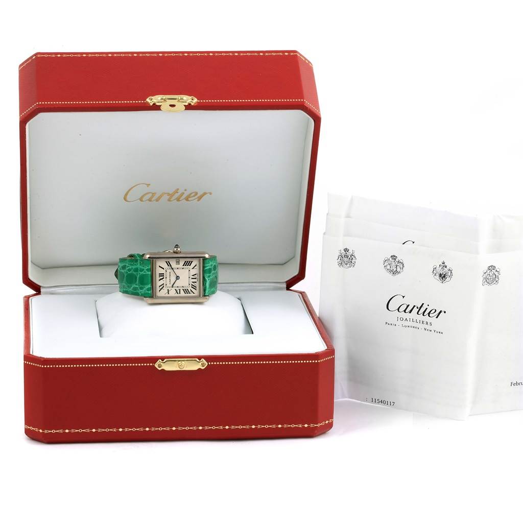 The Cartier Tank Louis W1540956 White Gold Silver Dial W1540956 White Gold Silver Dial watch is shown front-facing in an open red box, with official documents beside it.