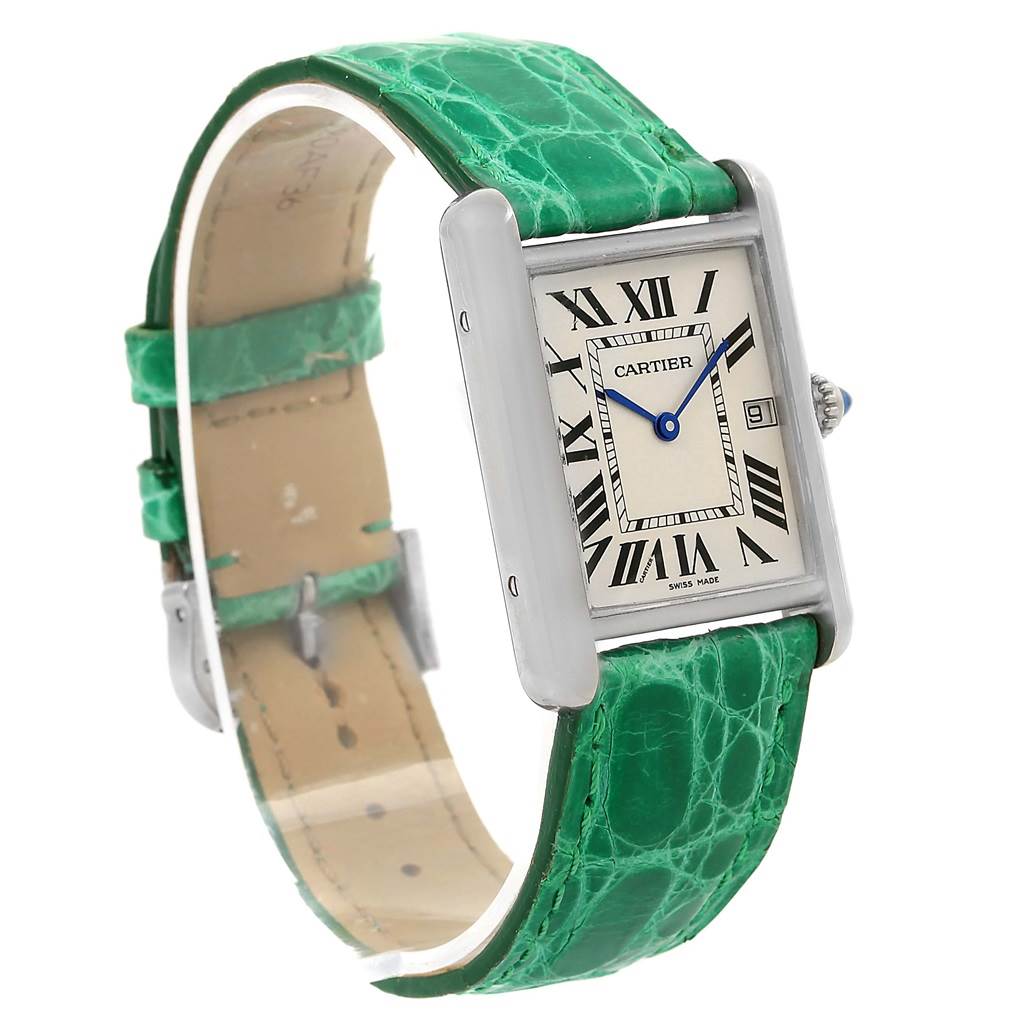 The image shows a Tank Louis Cartier watch positioned at an angle showcasing the face, green leather strap, and side profile.