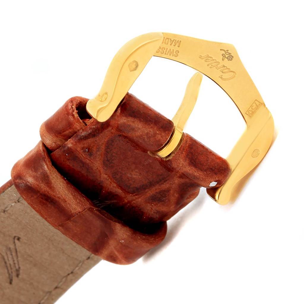 This image shows a close-up of the brown leather strap and gold buckle of a Cartier Tank Louis W1529856 Women's Yellow Gold Silver Dial W1529856 Women's Yellow Gold Silver Dial watch.