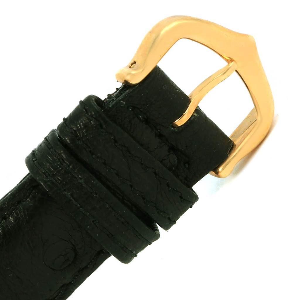 This image shows a close-up of the black leather strap and gold buckle of a Cartier Tank Louis W1529856 Women's Yellow Gold Silver Dial W1529856 Women's Yellow Gold Silver Dial watch.