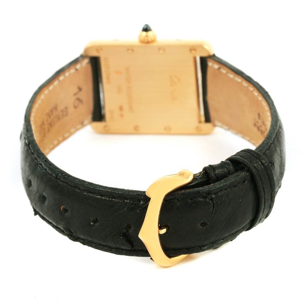 The image shows the back view of a Tank Louis Cartier watch, highlighting its black leather strap and gold buckle.