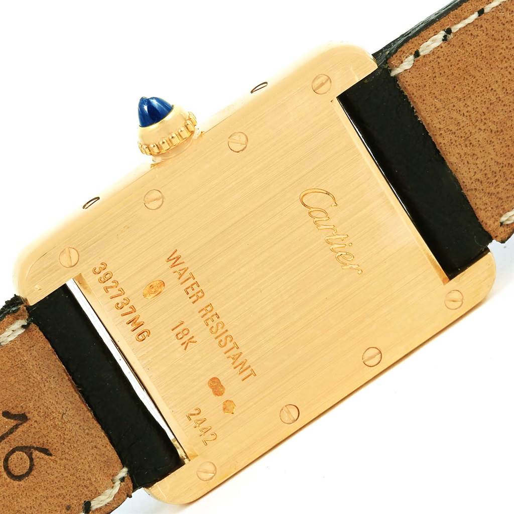 This image shows the back view of a Cartier Tank Louis W1529856 Women's Yellow Gold Silver Dial W1529856 Women's Yellow Gold Silver Dial watch, displaying inscriptions and a leather strap.