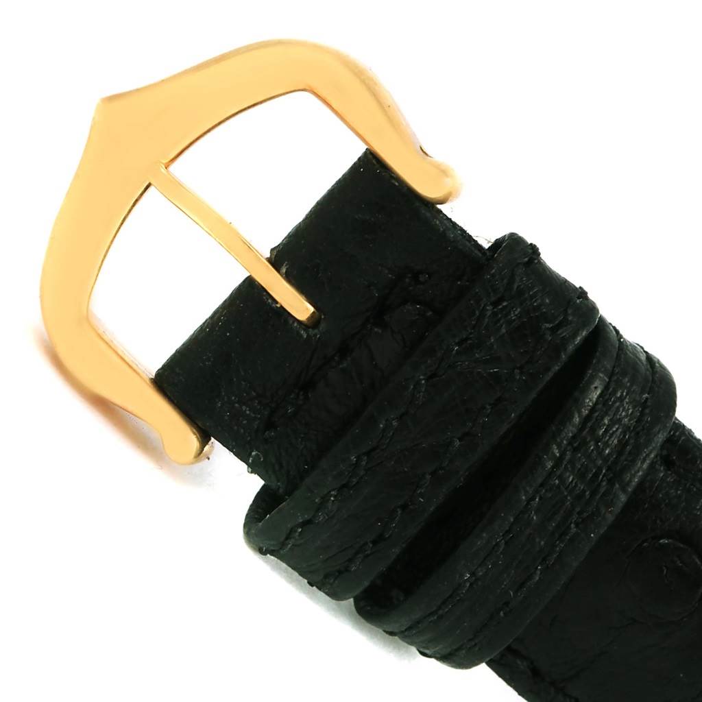This image shows the black leather strap and gold buckle of the Cartier Tank Louis W1529856 Women's Yellow Gold Silver Dial W1529856 Women's Yellow Gold Silver Dial watch from a close-up angle.